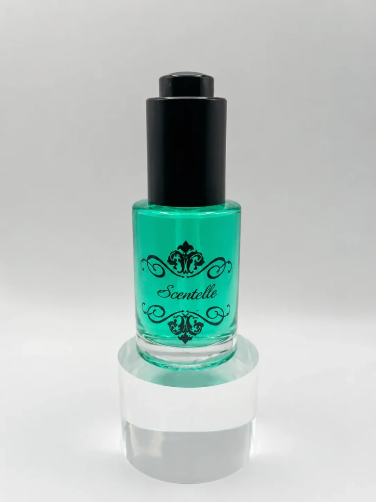 Scentelle 1 oz push-button dropper body oil in a glass bottle with green liquid and a black dropper cap.