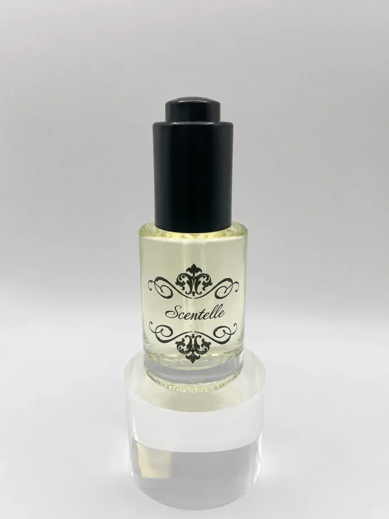 Scentelle 1 oz push-button dropper body oil in a glass bottle with yellow liquid and a black dropper cap.