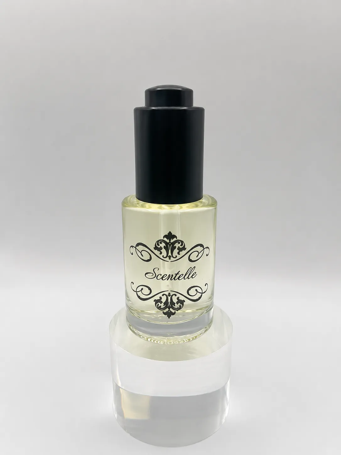 Scentelle 1 oz push-button dropper body oil in a glass bottle with yellow liquid and a black dropper cap.