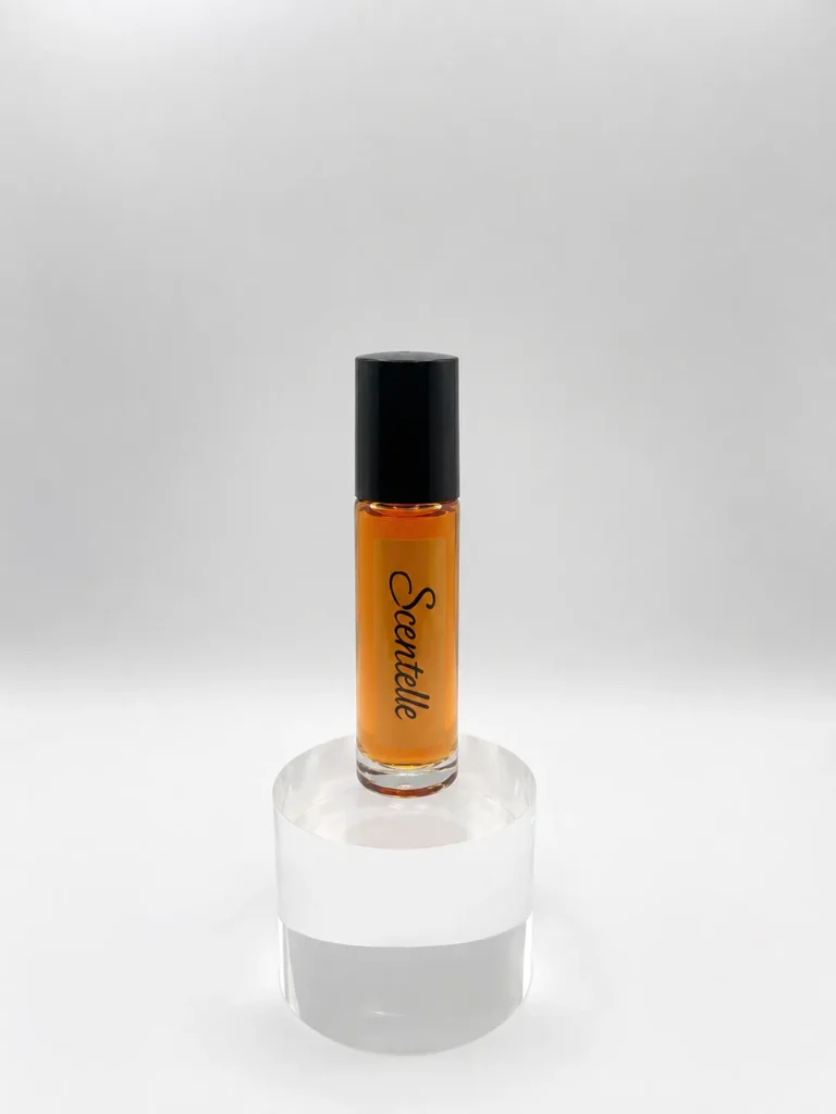 Scentelle 1/3 oz roll-on perfumed body oil in a tall glass bottle with orange liquid and a black cap.